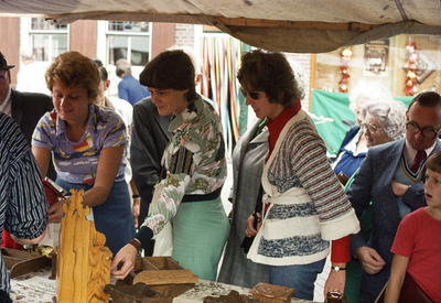 845706 Afbeelding van enkele bezoekers van een markt in de Spuistraat te Spakenburg (gemeente Bunschoten).